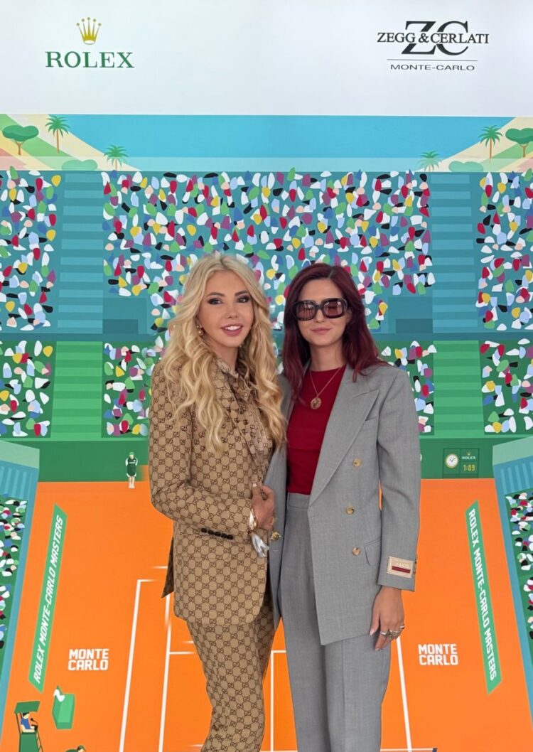 Lady Monika Bacardi and a guest posing at the Monte-Carlo Masters 2026 tennis event, showcasing elegance and style in a vibrant setting with sponsor logos including Rolex and Zegg & Cerlati.