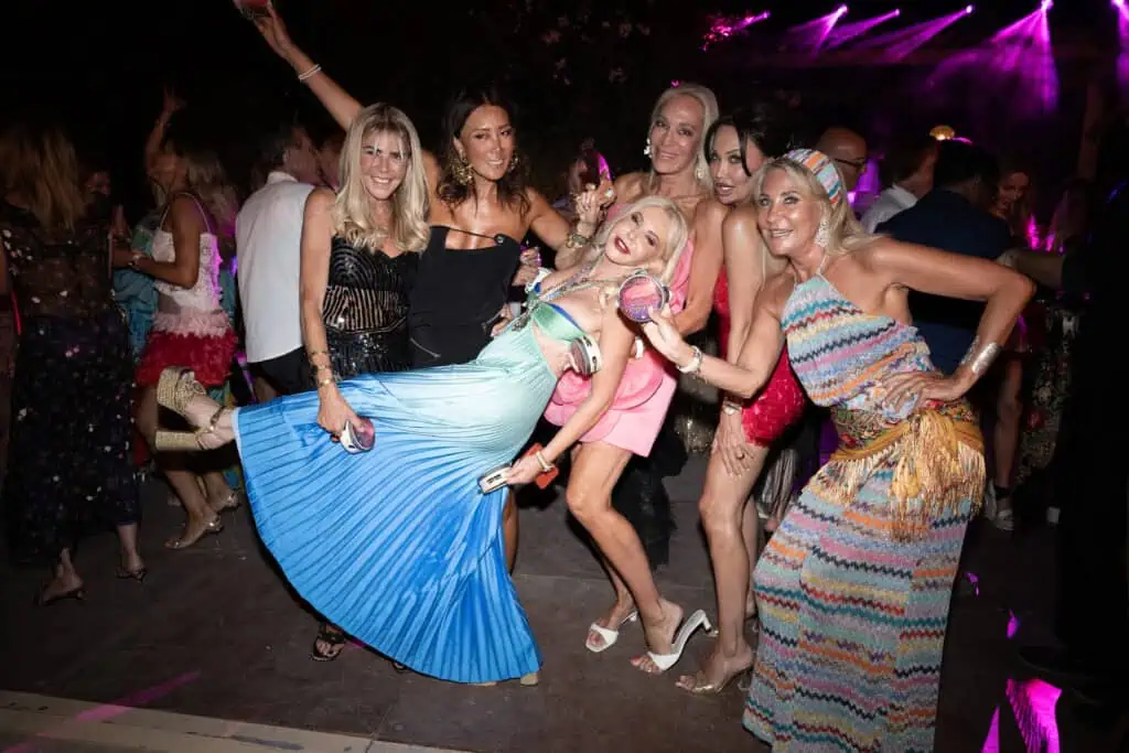 Lady Monika Bacardi and friends enjoying a vibrant night event in Saint-Tropez with colorful outfits and lively atmosphere.