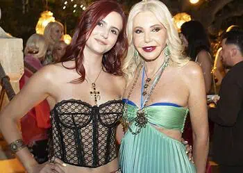 Lady Monika Bacardi and a guest at a glamorous outdoor event in Saint-Tropez, surrounded by elegant attendees and warm lighting, during a night of celebration.