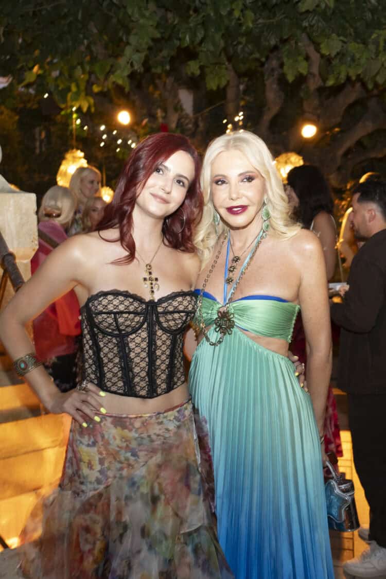 Lady Monika Bacardi and a guest at a glamorous outdoor event in Saint-Tropez, surrounded by elegant attendees and warm lighting, during a night of celebration.