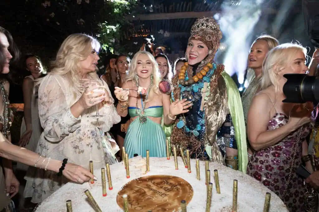Lady Monika Bacardi celebrating with friends at a glamorous Saint-Tropez event, wearing an elaborate costume and surrounded by a lively crowd.